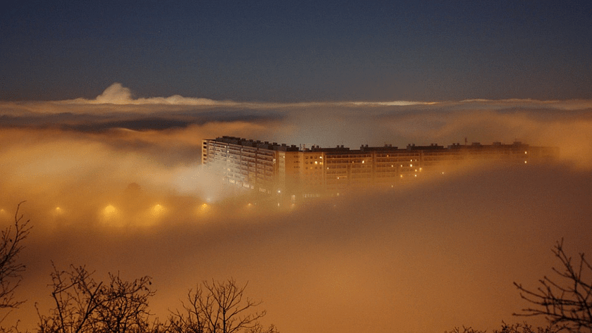 a condominium building covered in night fog