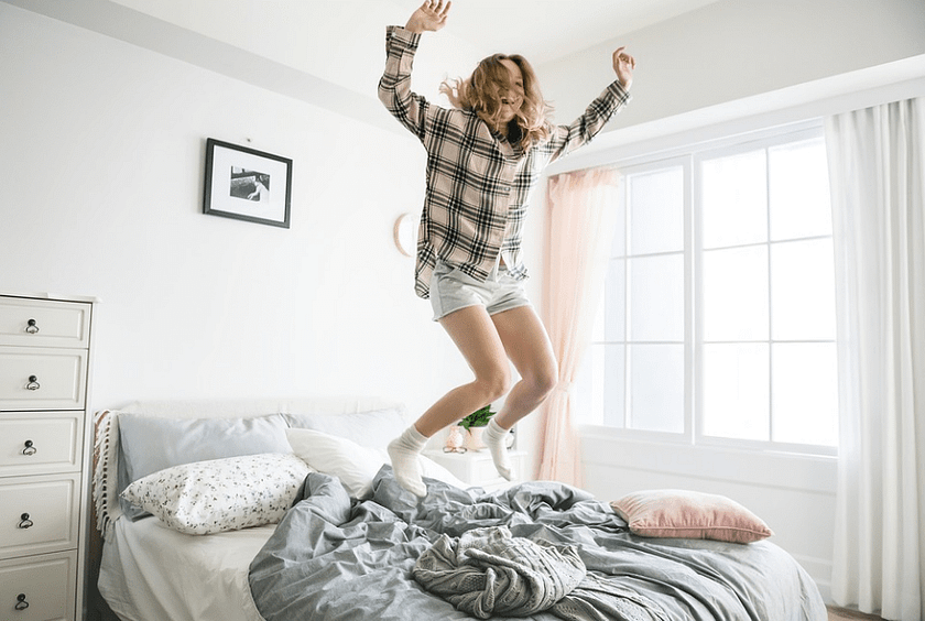 a woman jumping on the bed